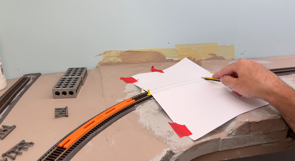 Marking the rail geometry shape with a pencil on a sheet of paper.