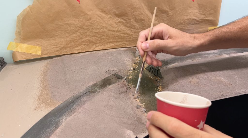 Bridge scenery: blending the rocks with more tile grout and a stiff brush