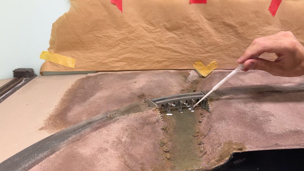 Bridge scenery: glueing the bridge in place with Liquitex matte medium.