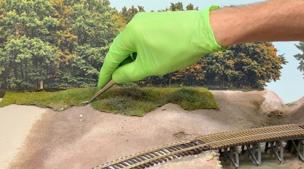 Burnishing the grass mat's edge with tweezers